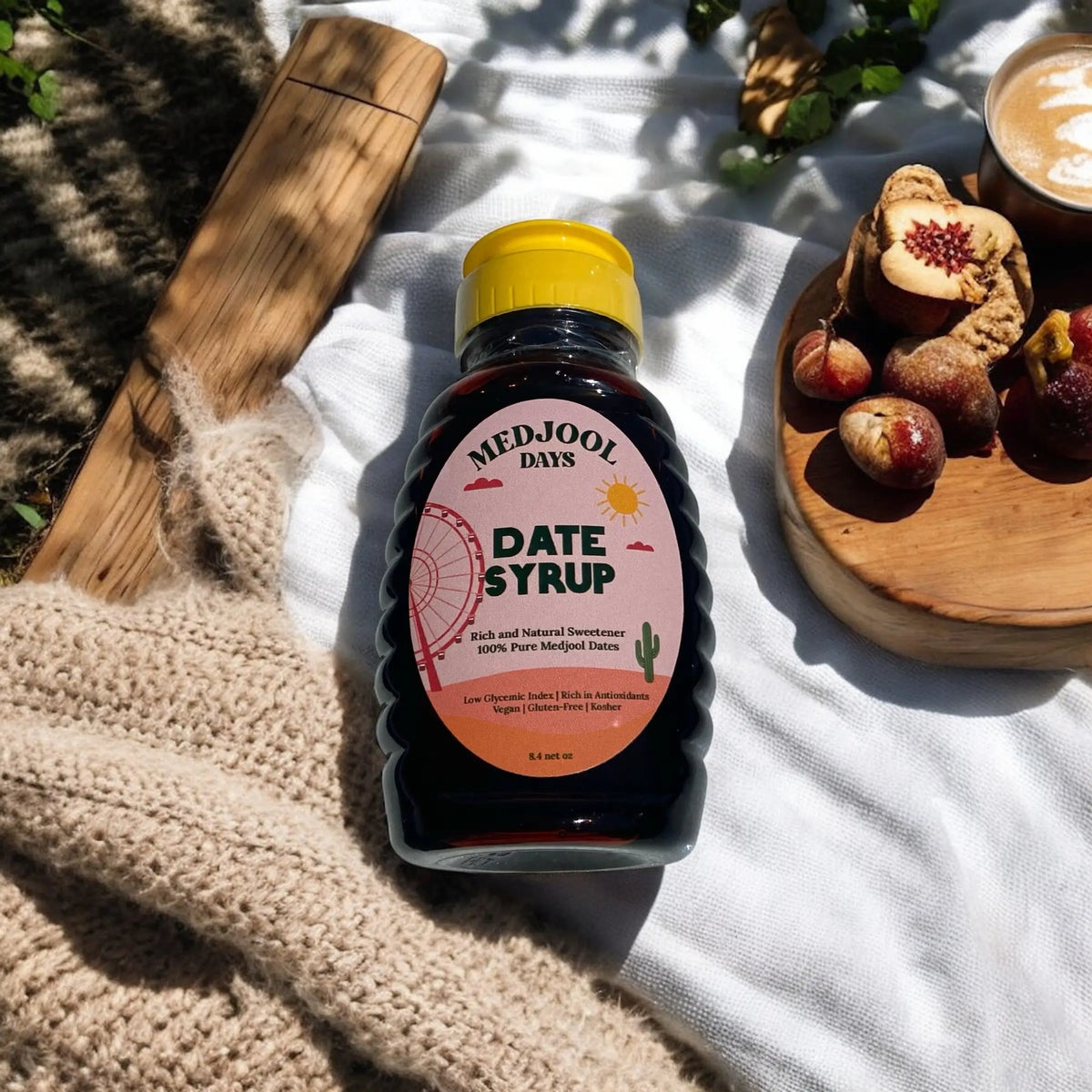 Organic Medjool Days date syrup bottle on picnic table with snacks ā pure Medjool date nectar for natural sweetening.