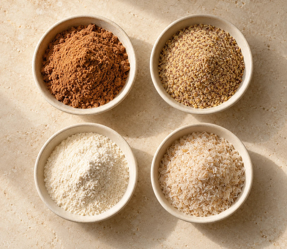 Four bowls illustrating date powder, ground flax, acacia fiber and psyllium husk.