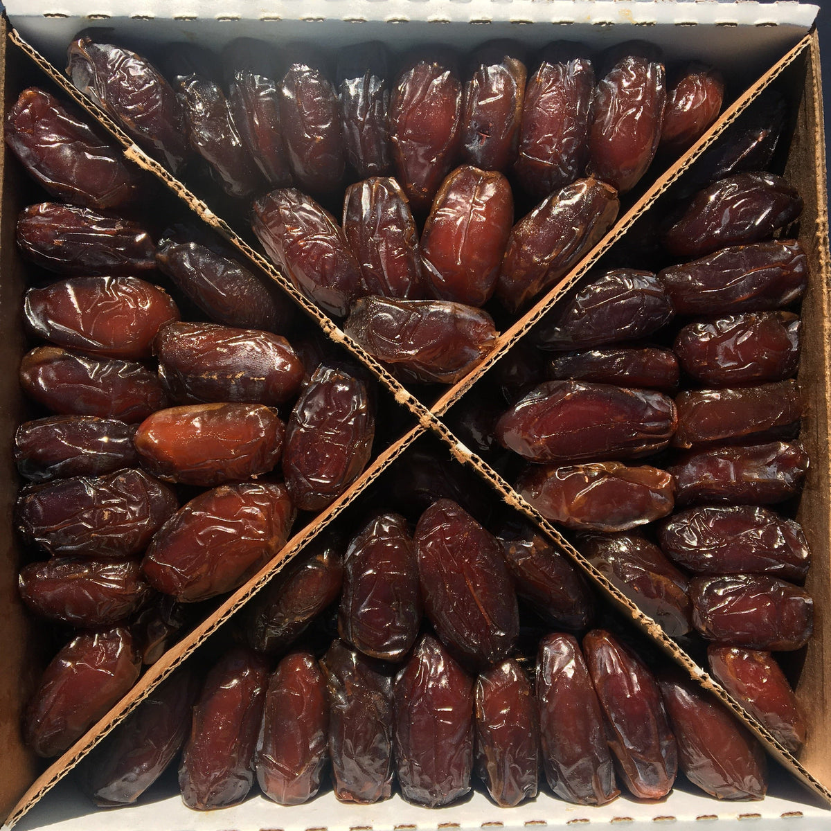 Open gift box filled with soft Medjool dates, each arranged in neat rows for visual appeal