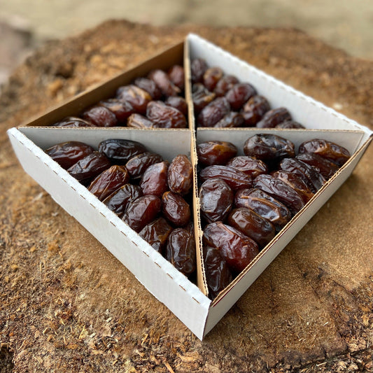Assorted date varieties styled on ceramic and wood serveware, paired with nuts