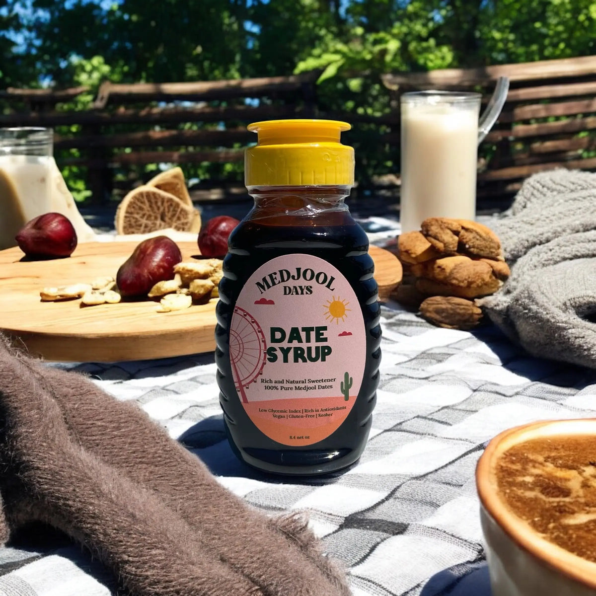 Medjool Days premium date syrup bottle on outdoor table with bread and coffee – all natural, organic Medjool date nectar.