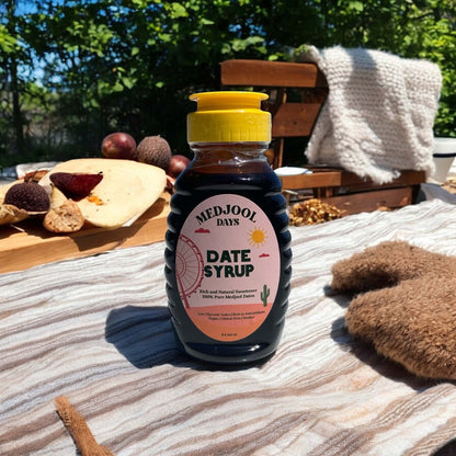 Premium Medjool Days date syrup bottle outdoors with figs and coffee – rich, all natural Medjool dates syrup.